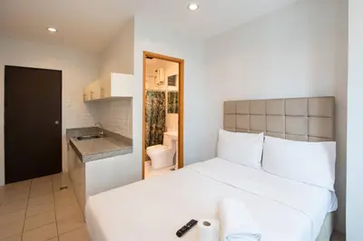 a bedroom with a white bed and a bathroom at JP Santiago Studio Makati J208 in Manila