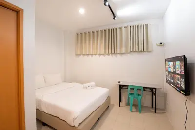a bedroom with a bed and a desk with a chair at JP Santiago Studio Makati J303 in Manila