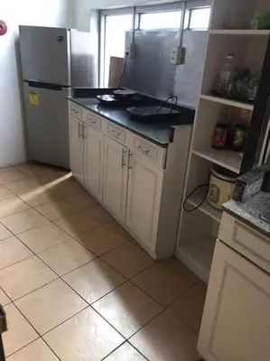 a kitchen with a refrigerator and a tiled floor at JP Santiago Studio Makati J303 in Manila