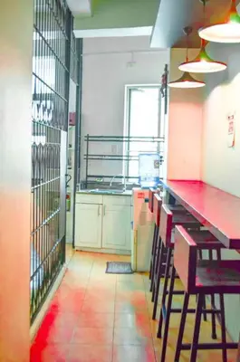 a kitchen with a red counter and chairs in it at JP Santiago Studio Makati J304 in Manila