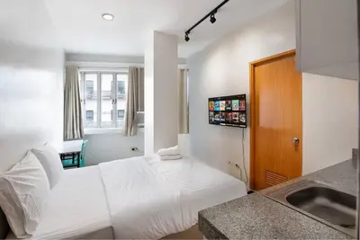 a hotel room with a white bed and a sink at JP Santiago Studio Makati J307 in Manila
