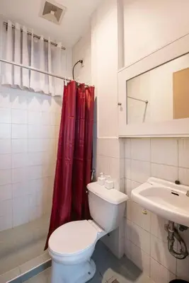a bathroom with a toilet and a red shower curtain at JP Santiago Studio Makati J308 in Manila
