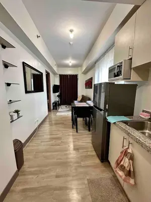 a kitchen and dining room with a table in a room at Staycation at Spring Residences in Paranaque in Manila