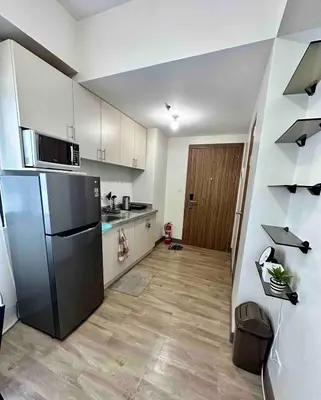 a kitchen with a stainless steel refrigerator in a room at Staycation at Spring Residences in Paranaque in Manila