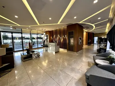 a lobby with couches and tables in a building at Staycation at Spring Residences in Paranaque in Manila