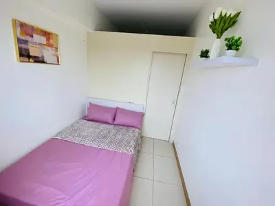 a small room with a purple bed in it at Luxury Two Bedroom with Balcony in SOUTH RESIDENCE of Las Pinas in Manila