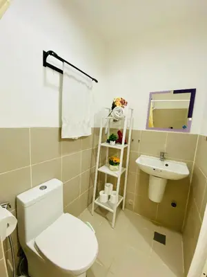 a bathroom with a white toilet and a sink at Luxury Two Bedroom with Balcony in SOUTH RESIDENCE of Las Pinas in Manila