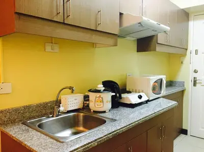 a kitchen counter with a sink and a microwave at Tivoli Garden Residences - Iris Tower in Manila