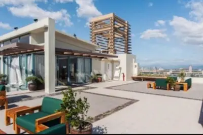 a building with a patio with green chairs and tables at Tivoli Garden Residences - Iris Tower in Manila