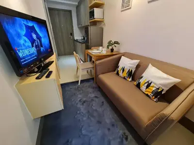a living room with a couch and a flat screen tv at Chic 2 Bedroom EDSA APT with Balcony in Manila