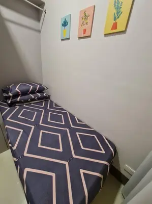 a bedroom with a bed in a room with pictures on the wall at Chic 2 Bedroom EDSA APT with Balcony in Manila