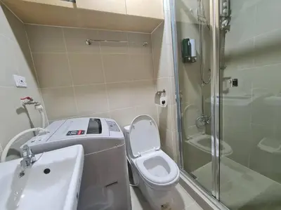 a bathroom with a shower and a toilet and a sink at Chic 2 Bedroom EDSA APT with Balcony in Manila