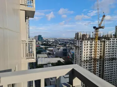 a view of a city from the balcony of a building at Chic 2 Bedroom EDSA APT with Balcony in Manila