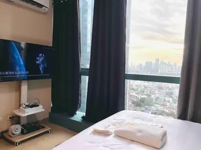 a bedroom with a bed and a large window at One Uptown 2-bed 1BR w/XBOX, Netflix in BGC in Manila