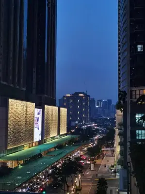 a city street at night with traffic and buildings at One Uptown 2-bed 1BR w/XBOX, Netflix in BGC in Manila