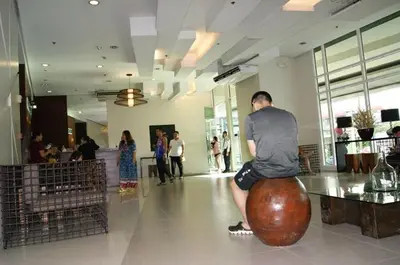 a man sitting on a large ball in a building at The Beacon Makati by mvmtransient in Manila