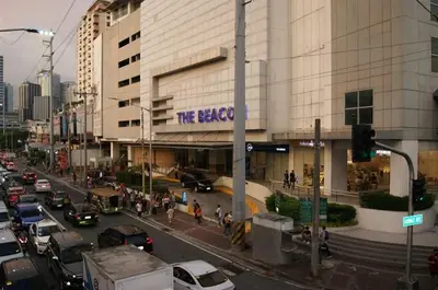 a busy city street with cars parked in front of a building at The Beacon Makati by mvmtransient in Manila