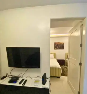 a room with a flat screen tv on a wall at 40 Percent Promo Off This Month, Balcony Ocean View Plus Free Pool & Sauna Access Exclusive 2025 Rates at Walking Distance US Embassy, Front of Robinsons Place MANILA, Bellagio and Experience Breathtaking Manila Bay Views in Manila