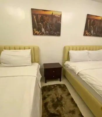 a room with two beds and a table between them at 40 Percent Promo Off This Month, Balcony Ocean View Plus Free Pool & Sauna Access Exclusive 2025 Rates at Walking Distance US Embassy, Front of Robinsons Place MANILA, Bellagio and Experience Breathtaking Manila Bay Views in Manila