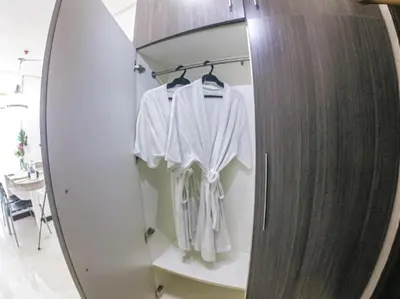 a closet with white shirts on hangers in a room at Family Room Staycation In The Heart Of Manila, with 2 Balcony Plus 40 Percent Promo Discount Plus Free Pool Access, Plus Free Sauna Promo in Manila Bay, Robinsons Place, Ermita, Pgh, Bellagio, UP Pedrogil, Staycation Updated 2025 Price in Manila