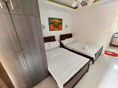 two twin beds in a room with a closet at Family Room Staycation In The Heart Of Manila, with 2 Balcony Plus 40 Percent Promo Discount Plus Free Pool Access, Plus Free Sauna Promo in Manila Bay, Robinsons Place, Ermita, Pgh, Bellagio, UP Pedrogil, Staycation Updated 2025 Price in Manila