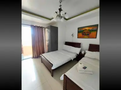 a hotel room with two beds and a window at Family Room Staycation In The Heart Of Manila, with 2 Balcony Plus 40 Percent Promo Discount Plus Free Pool Access, Plus Free Sauna Promo in Manila Bay, Robinsons Place, Ermita, Pgh, Bellagio, UP Pedrogil, Staycation Updated 2025 Price in Manila