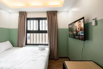 a bedroom with a bed and a tv on the wall at St. Marvin Studio Makati M308 in Manila