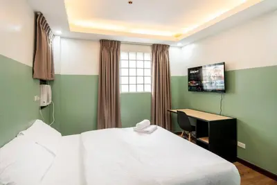 a bedroom with a bed and a desk with a computer at St. Marvin Studio Makati M307 in Manila