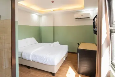 a small room with a bed and a television at St. Marvin Studio Makati M306 in Manila