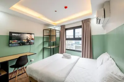 a bedroom with a bed and a desk and a tv at St. Marvin Studio Makati M304 in Manila