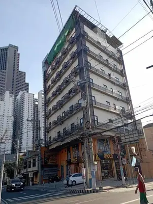 a tall building on a city street with cars at St. Marvin Studio Makati M303 in Manila
