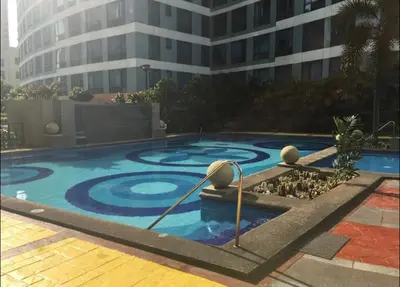 a large swimming pool in front of a building at Awesome Eastwood Condo Suite! in Manila