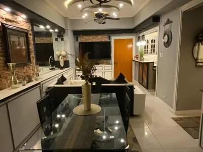a kitchen with a glass table with a vase on it at Awesome Eastwood Condo Suite! in Manila