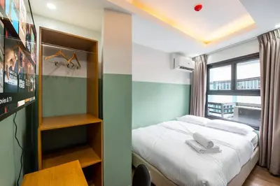 a small bedroom with a bed and a window at St. Marvin Studio Makati M302 in Manila