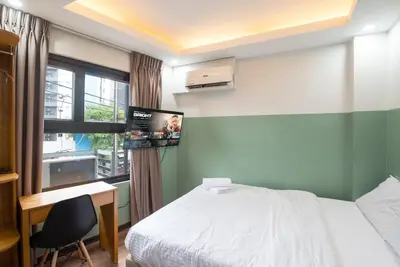a bedroom with a bed and a desk and a window at St. Marvin Studio Makati M301 in Manila