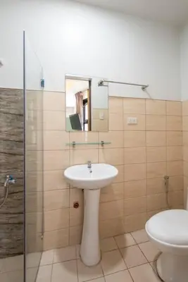 a bathroom with a sink and a toilet and a mirror at St. Marvin Studio Makati M301 in Manila