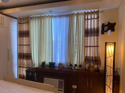 a bedroom with a bed and a large window at Elegant 2BR, 2 BA Suite Beside Eastwood Mall in Manila