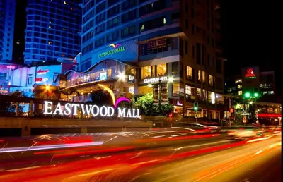 a city street at night with a sign that reads eastwood mall at Elegant 2BR, 2 BA Suite Beside Eastwood Mall in Manila