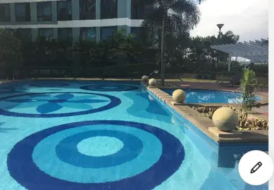 a large swimming pool with a blue design on it at Elegant 2BR, 2 BA Suite Beside Eastwood Mall in Manila