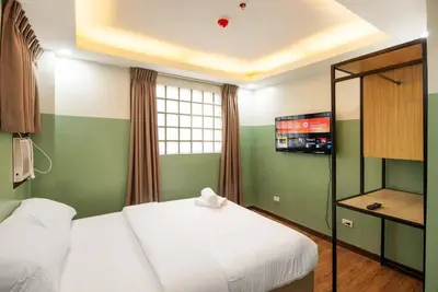a hotel room with a bed and a tv at St. Marvin Studio Makati M207 in Manila