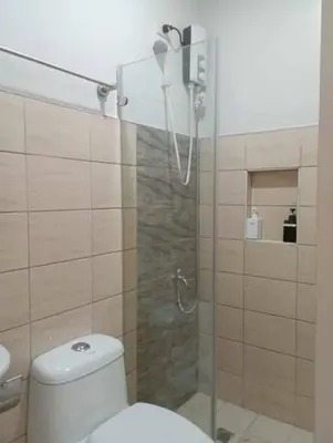 a bathroom with a toilet and a glass shower at St. Marvin Studio Makati M207 in Manila