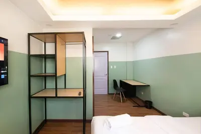 a bedroom with a bed and a desk and a chair at St. Marvin Studio Makati M207 in Manila