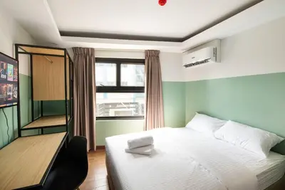 a bedroom with a white bed and a window at St. Marvin Studio Makati M203 in Manila