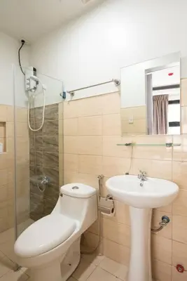 a bathroom with a toilet and a sink and a shower at St. Marvin Studio Makati M203 in Manila