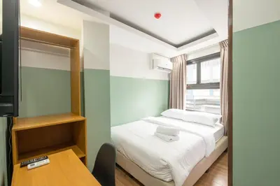 a small bedroom with a bed and a table at St. Marvin Studio Makati M202 in Manila