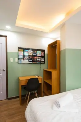a bedroom with a bed and a desk and a chair at St. Marvin Studio Makati M202 in Manila