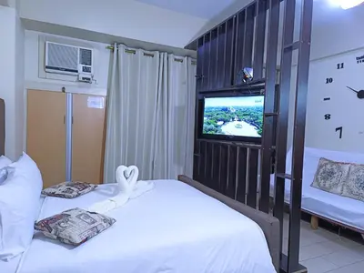 a hotel room with two beds and a tv at Palmtree Two Villas Across Terminal 3 or Manila Airport in Manila