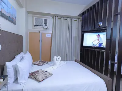 a hotel room with two beds and a television at Palmtree Two Villas Across Terminal 3 or Manila Airport in Manila