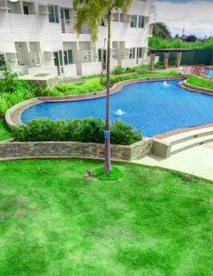 a swimming pool with a palm tree in a yard at Anuva Residence Condominium in Manila