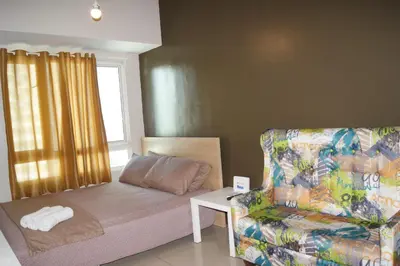 a room with a bed and a couch and a chair at The Beacon Makati by mvmtransient in Manila